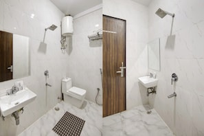 Bany modern amb vàter, rentaplat i dutxa, i una porta de fusta.