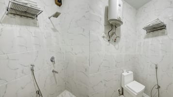Une salle de bain équipée de toilettes, d’une douche et d’un porte-serviettes.