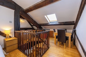 A room with a wooden staircase, a desk with a chair, a lamp, and a skylight. - Modern 2-BR Loft Flat W/Parking near Lime St (Liverpool)