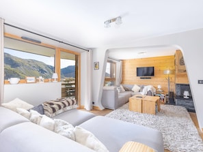 A modern living room with a sofa, a television, and a fireplace. - Kouria 1, Splendide appartement 4 pièces pour 8 personnes à Avoriaz (Morzine)