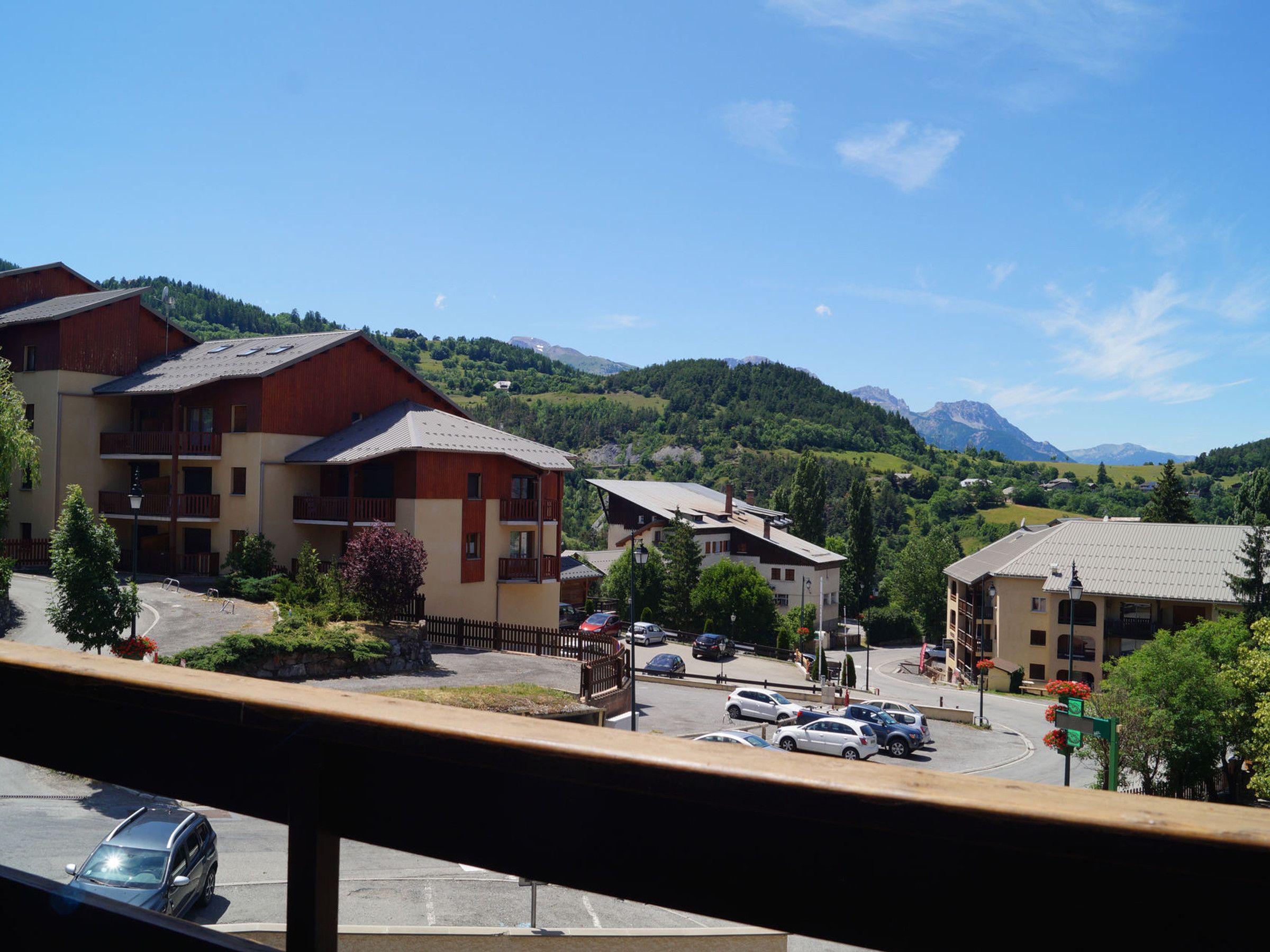 A hotel with multiple buildings, a parking lot, and a mountainous backdrop.