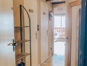 A corridor with a wooden door, a metal shelf, and a sign reading 'Salle de Bain'. - Studio apartment at the foot of the slopes - 6 guests (Huez)