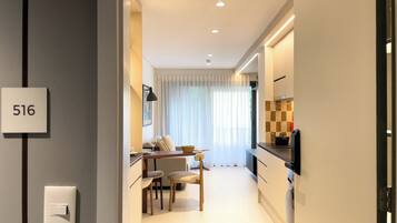 A modern kitchen with a dining area, a number sign '516' on the wall, and a visible light switch.