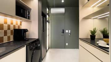 A modern kitchen with a dishwasher, microwave, and an air conditioning unit.