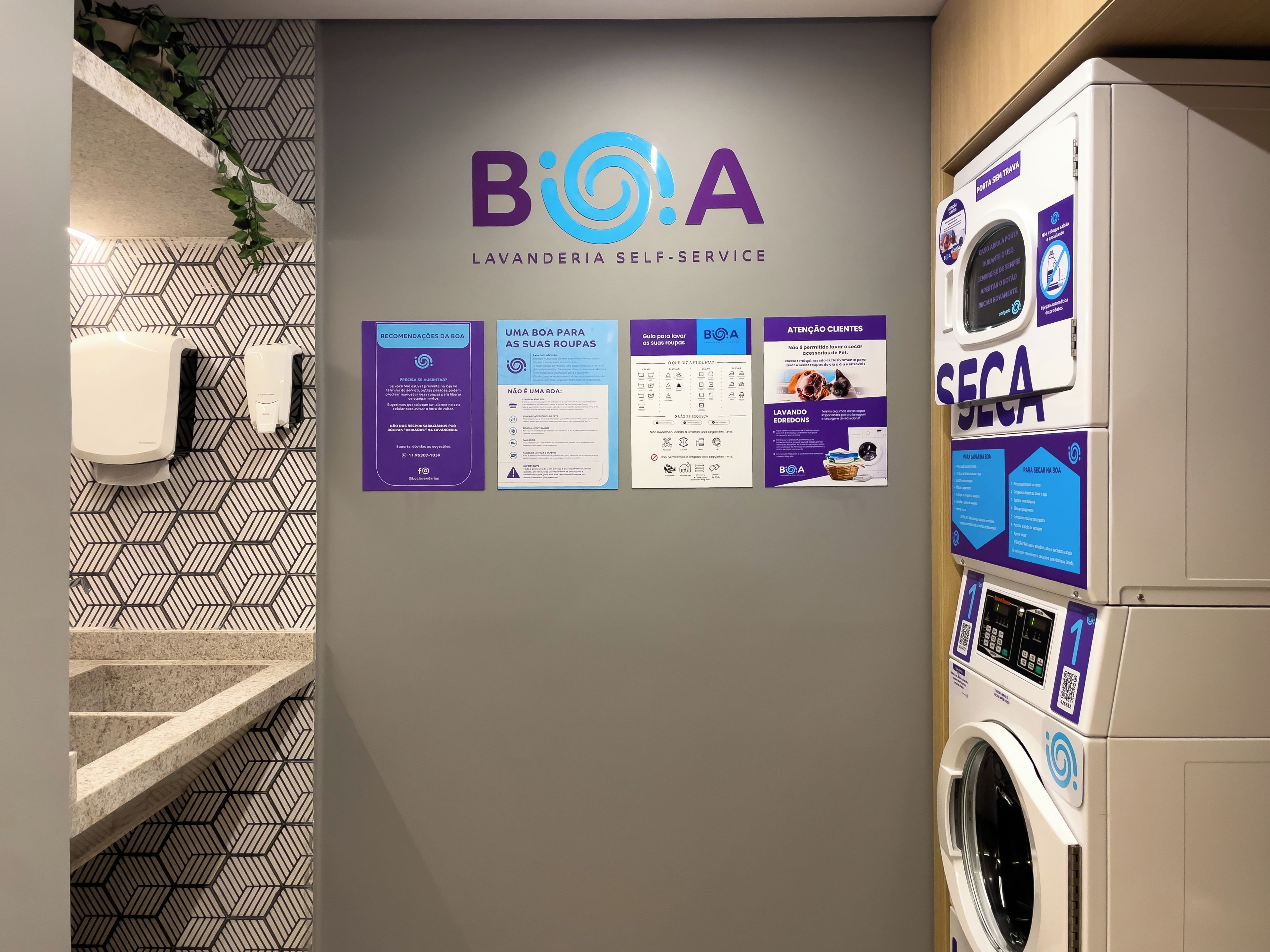 A self-service laundry area with a wall-mounted sign displaying the logo and name 'BioA' along with various instructions and guidelines for use.