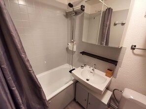 Ein Badezimmer mit Badewanne, Waschbecken, Spiegel und Dusche.