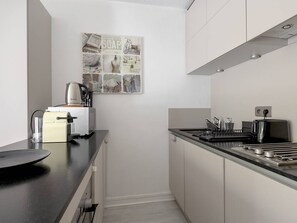A compact kitchen with a coffee machine, a toaster, and a sink. - Quiet studio near beach - 3 guests (Arcachon)