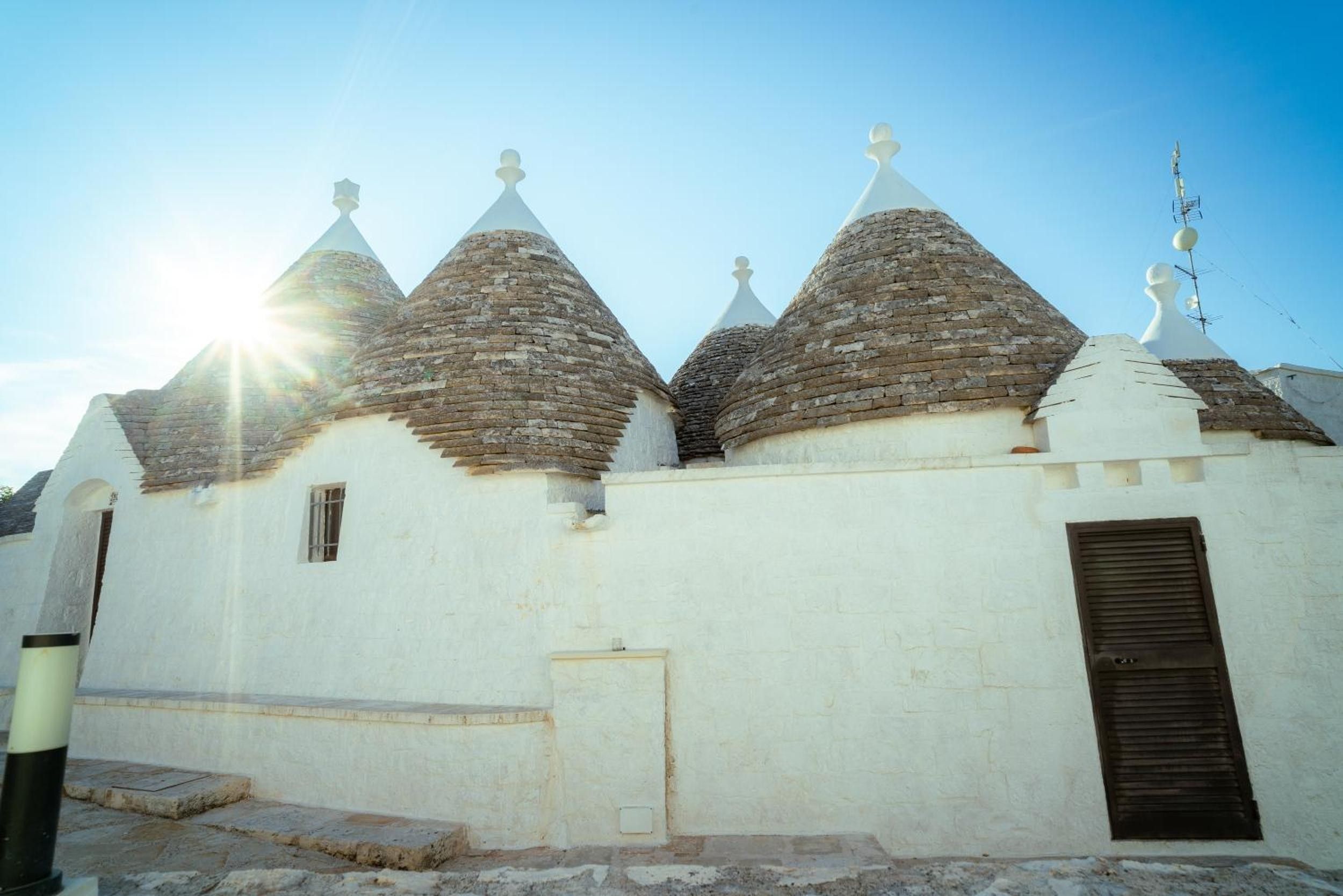 A building with multiple conical roofs and a single door.