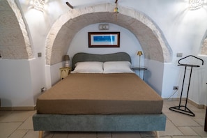 A bedroom with a large bed, a nightstand, a lamp, and a framed picture on the wall. - Apartment 'Stella' with Shared Pool, Shared Terrace and Wi-Fi (Locorotondo)