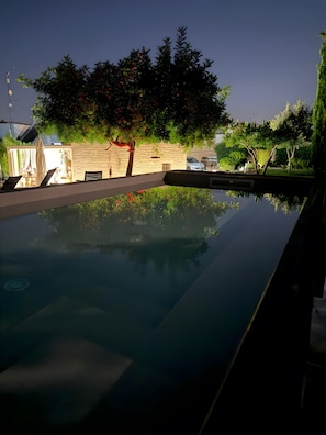 A swimming pool with a stone wall and greenery in the background. - Apartment 'Stella' with Shared Pool, Shared Terrace and Wi-Fi (Locorotondo)