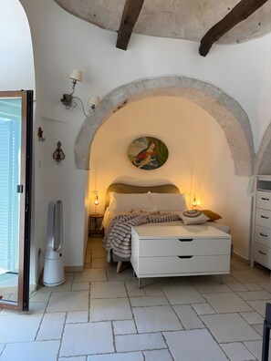 Un dormitorio con cama, un cuadro, una lámpara y un calentador.