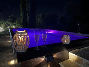 An outdoor pool area with a table, two glasses, and two lanterns. - Room 'Perla' with Shared Pool, Shared Terrace and Wi-Fi (Locorotondo)