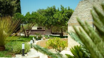 A landscaped garden with a stone pathway, various shrubs, and trees.