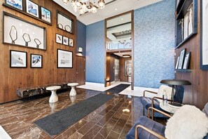 A lobby with a reception desk, seating area, and a staircase leading to an upper floor. - Pioche Basecamp | Deer Valley + Mountain Views (Park City)