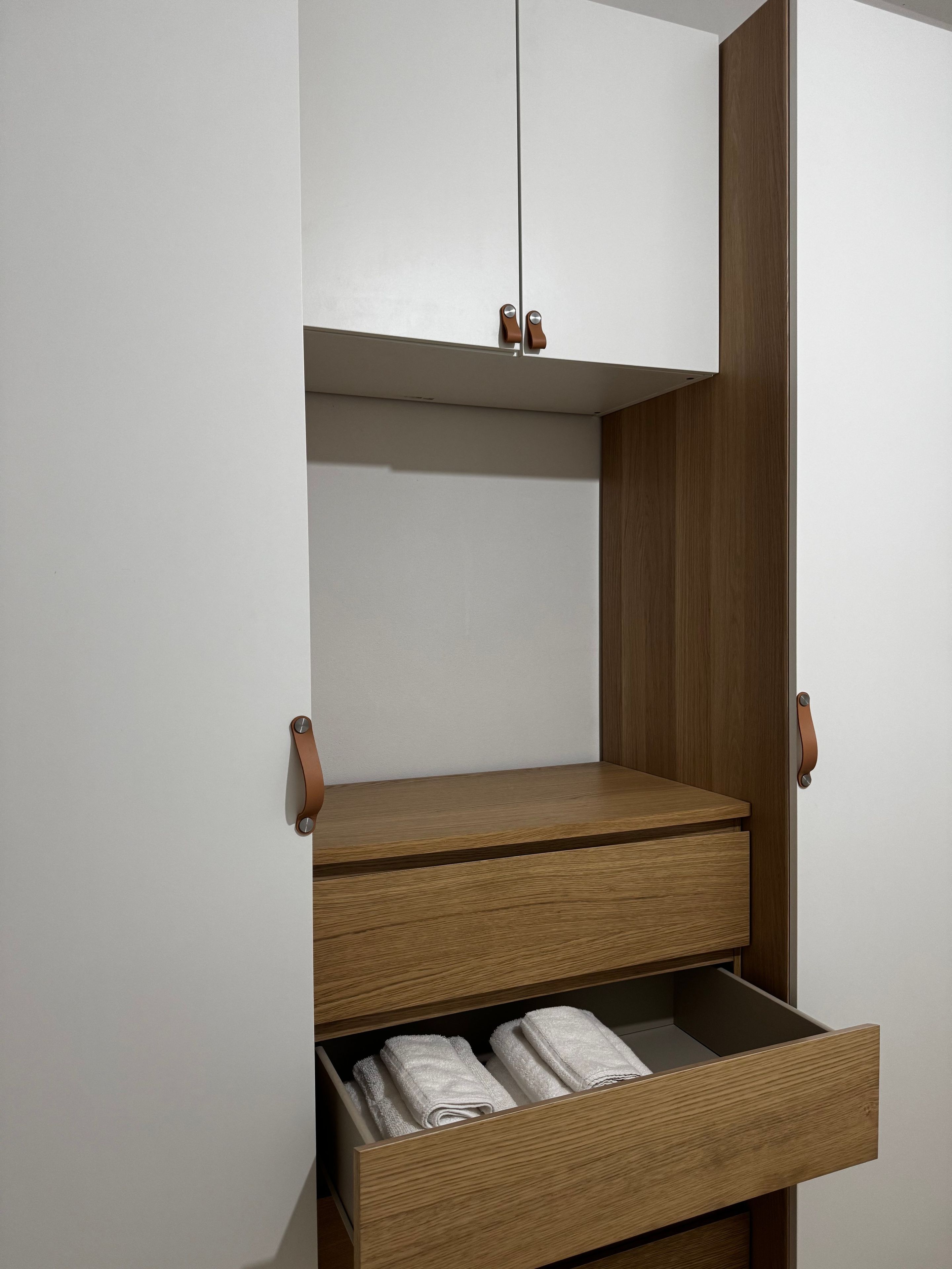 A wardrobe with a hanging rod, a shelf, and two drawers.
