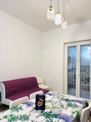 Ein Essbereich mit einem Tisch für zwei Personen, einer Barilla-Pastapackung und einem Fenster mit Blick.