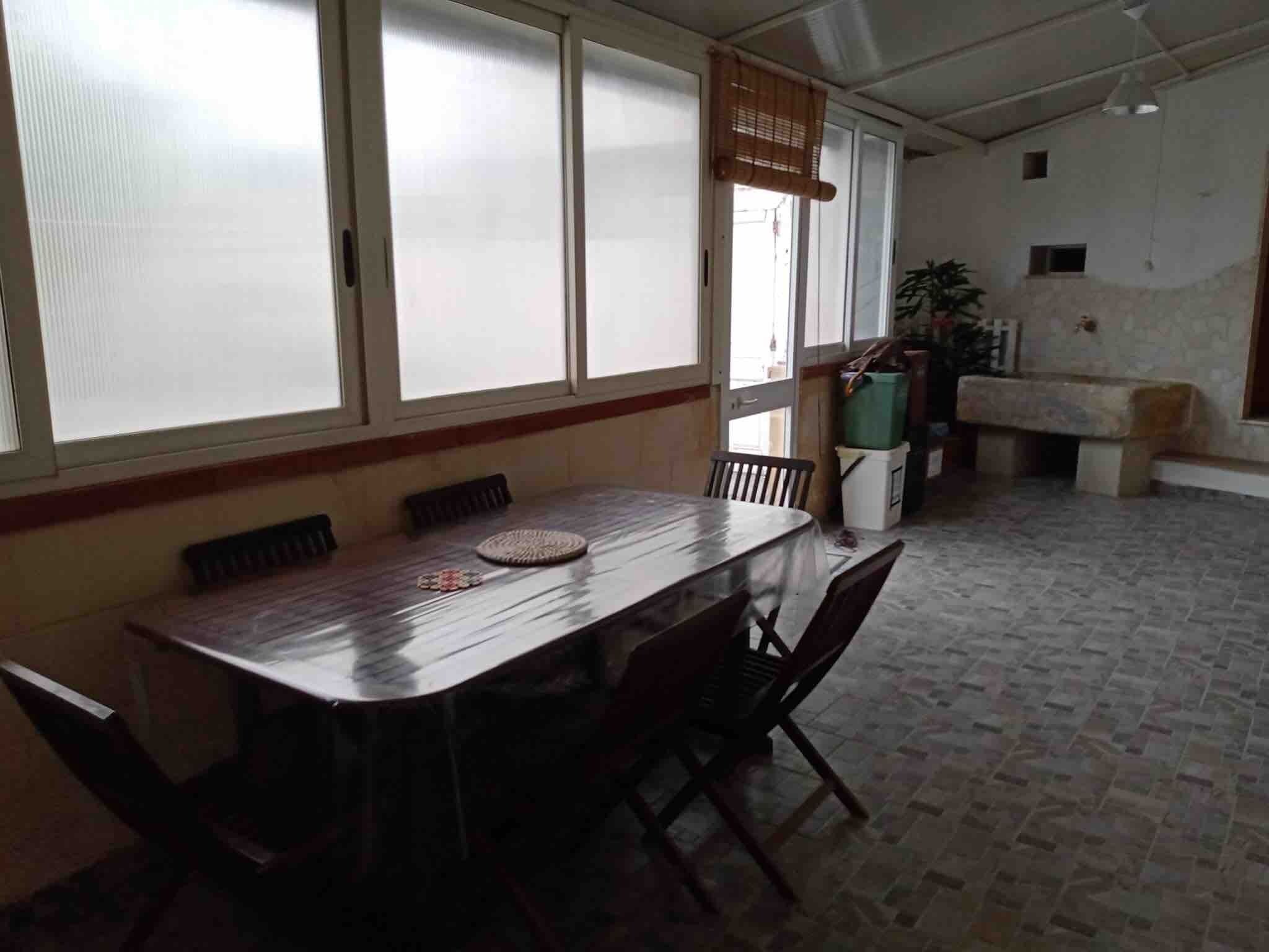 Un espace repas comprenant une longue table, des chaises et un banc.