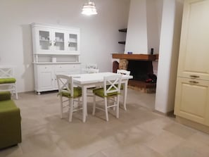 A compact living space with a dining table, chairs, a cabinet, and a fireplace. - Holiday home 'Da Gigetto Tuturano' with private garden and Wi-Fi (Tuturano)