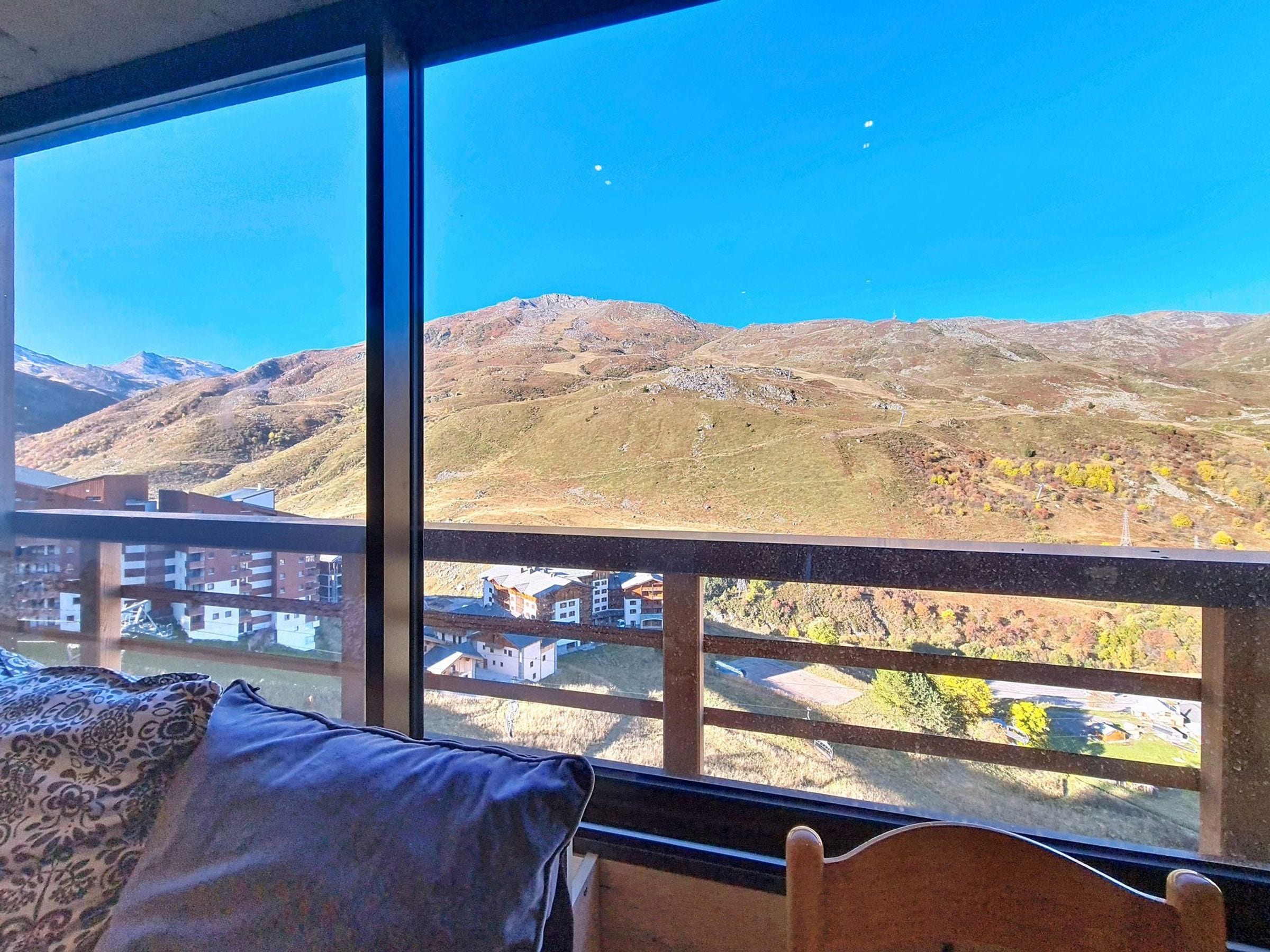 A room with a large window overlooking a mountainous landscape.