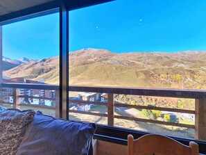 A room with a large window overlooking a mountainous landscape. - Pleasant apartment at the foot of the slopes - 4 guests (Les Menuires)