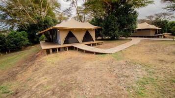 A campsite with two tents, each with a wooden platform and a ramp leading to the entrance.