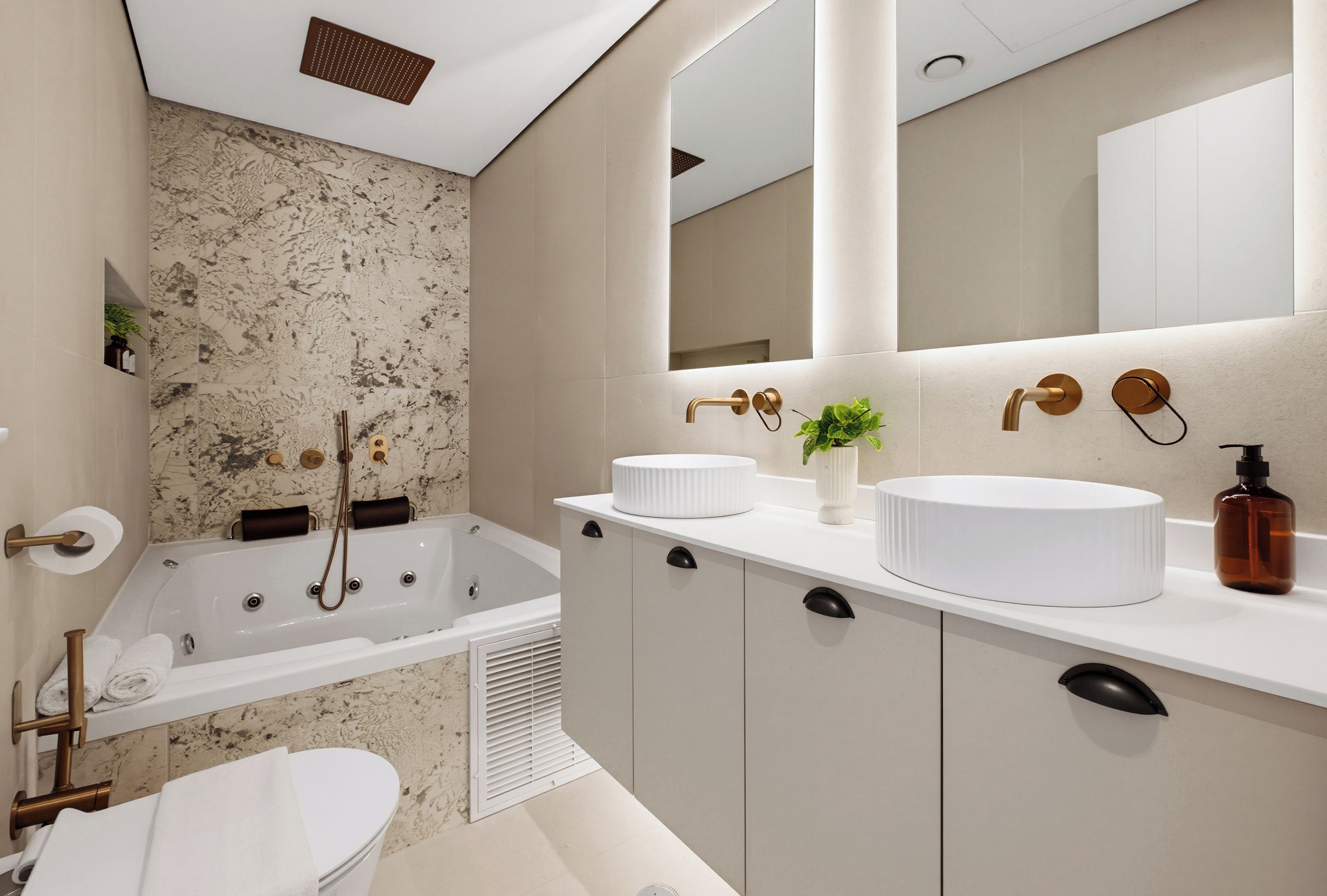 A modern bathroom with a freestanding bathtub, a toilet, and a vanity with a mirror.