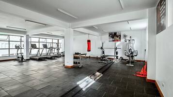 A gym with treadmills, weight machines, and a punching bag.