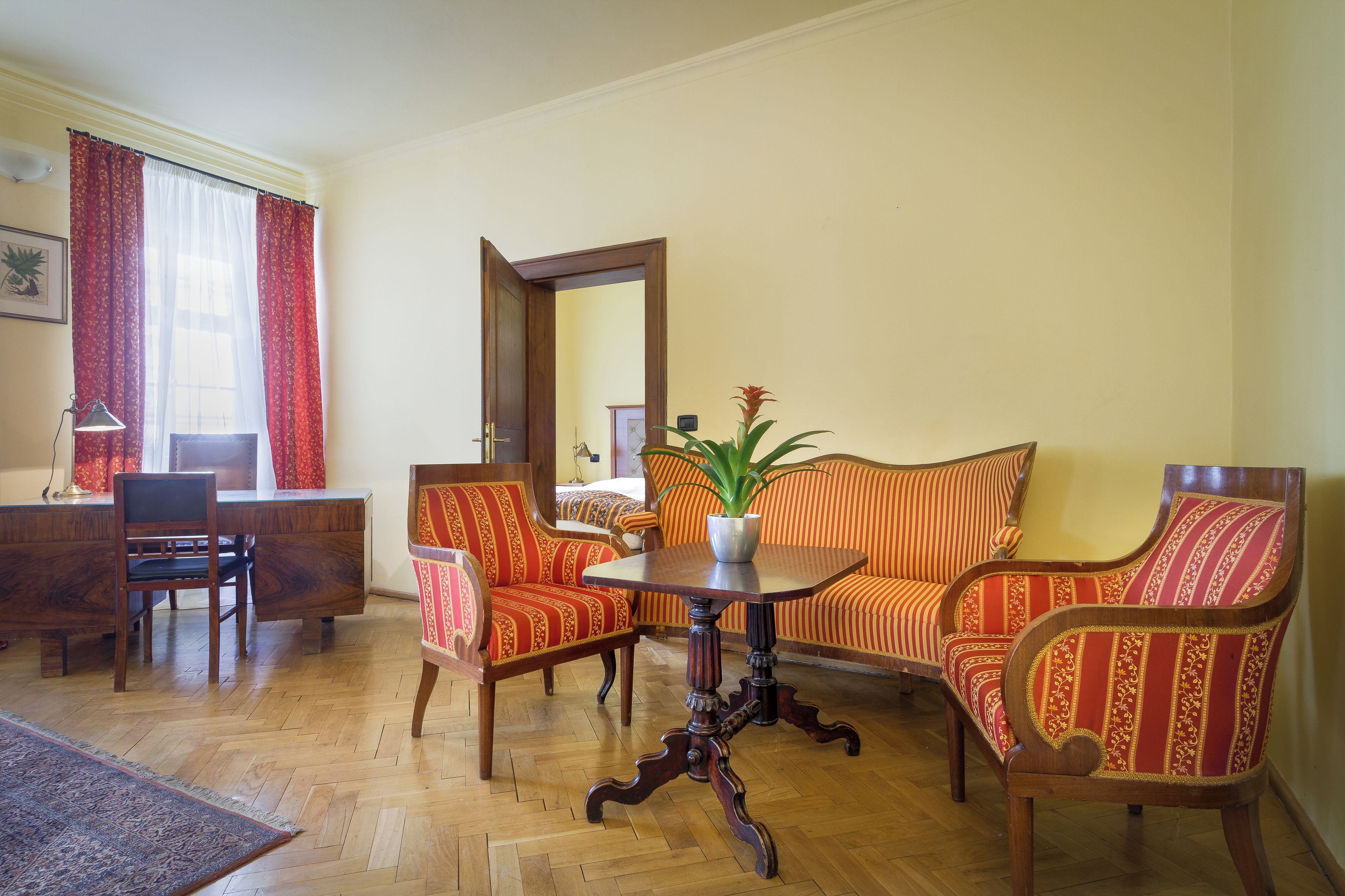 Una habitación con piso de madera, un sofá, una mesa de comedor y una silla.