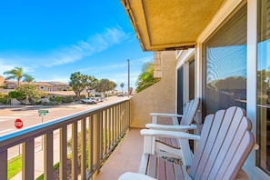 A balcony with white Adirondack chairs, a stop sign, and a view of a street with houses and palm trees. - 25% Off Oct 29-31 Walk 2 Beach/Shops -Pool,Jacuzzi (Ventura)
