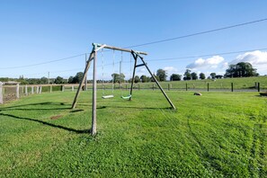 A grassy field with a wooden swing set. - Cottage 'Gite La Landette' with Private Terrace, Private Garden and Wi-Fi (Lapenty)