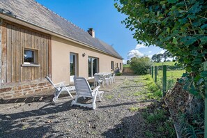 A building with a sloped roof, a brick chimney, and a gravel driveway. - Cottage 'Gite La Landette' with Private Terrace, Private Garden and Wi-Fi (Lapenty)