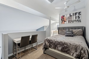 A bedroom with a bed, a desk, two chairs, and a ceiling fan. - Breckenridge Studio Retreat | Great Location (Breckenridge)