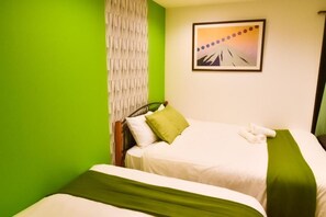 A hotel room with two beds, a green wall, and a framed picture of a mountain. - One More Heart Kyoto Station South 4 (Kyoto)