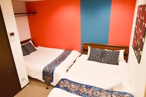 A room with two beds, each with patterned bedding and a headboard. - One More Heart Kyoto Station South 4 (Kyoto)