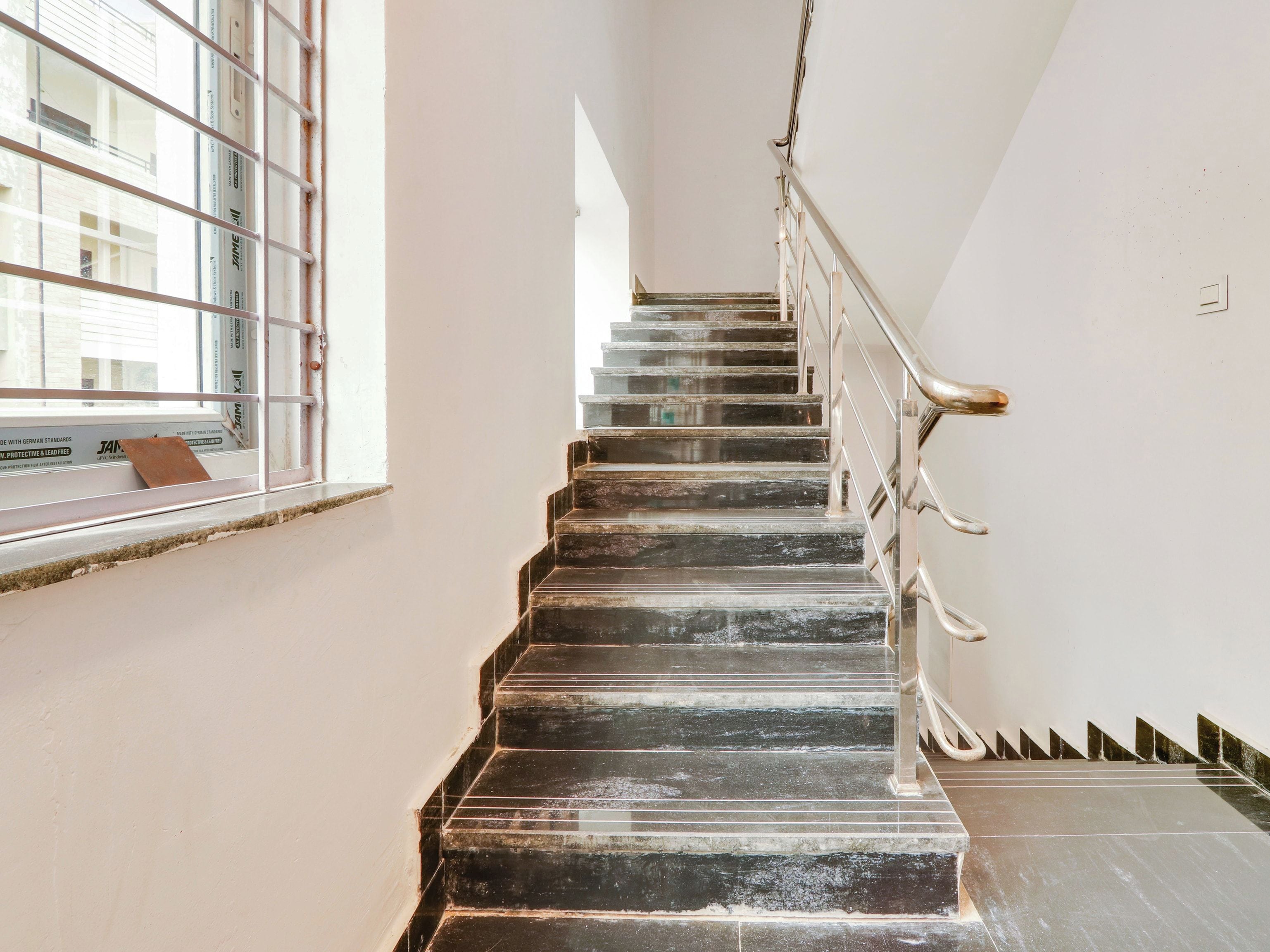 A staircase with a metal railing, leading to an upper floor.
