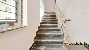 A staircase with a metal railing, leading to an upper floor.