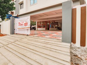 A hotel entrance with a sign indicating availability, a tiled floor, and a scooter parked outside. - Collection O White Ridge Kamineni (Hyderabad)
