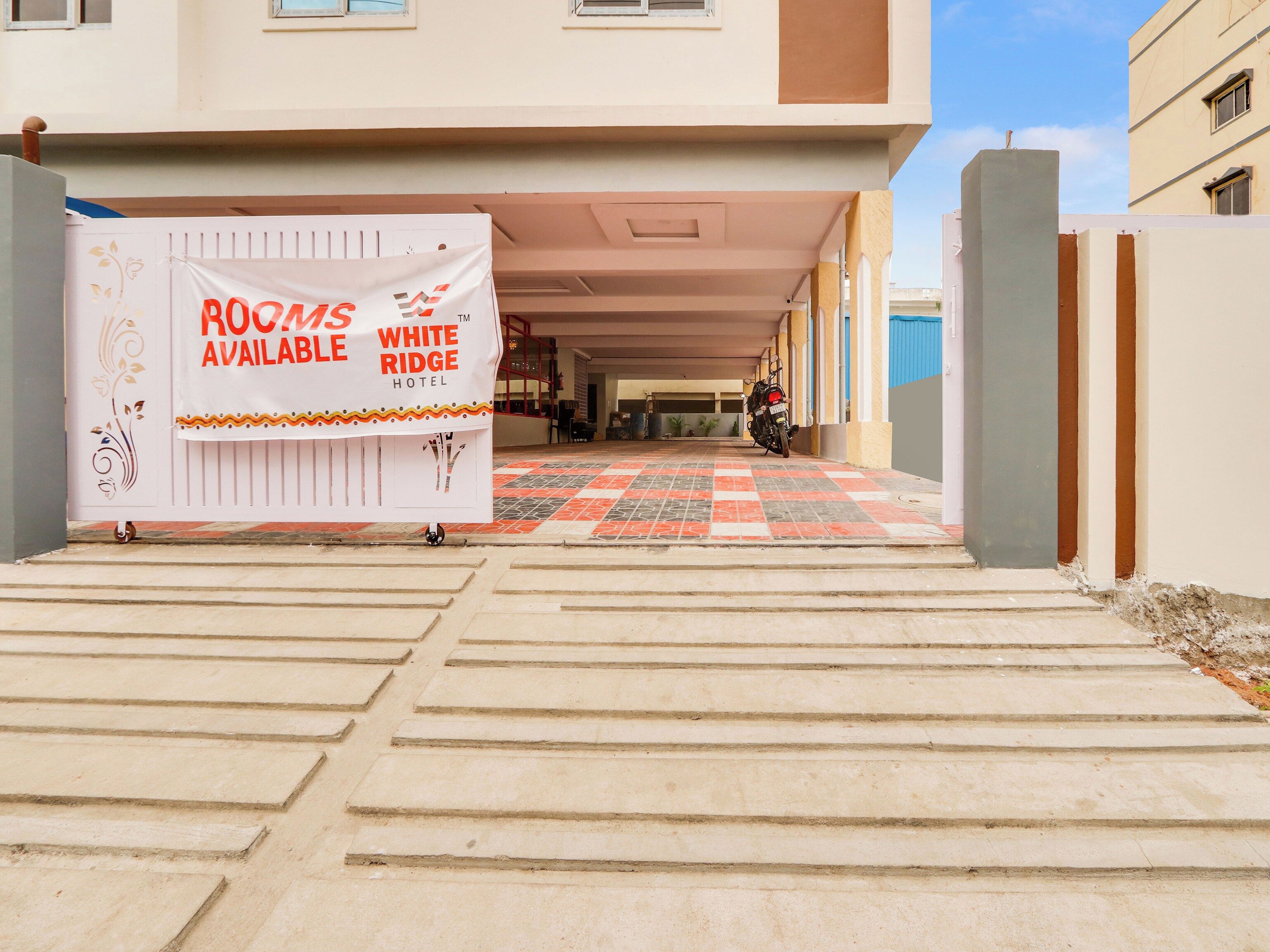 Entrada de hotel con un cartel publicitando habitaciones disponibles en White Ridge Hotel.