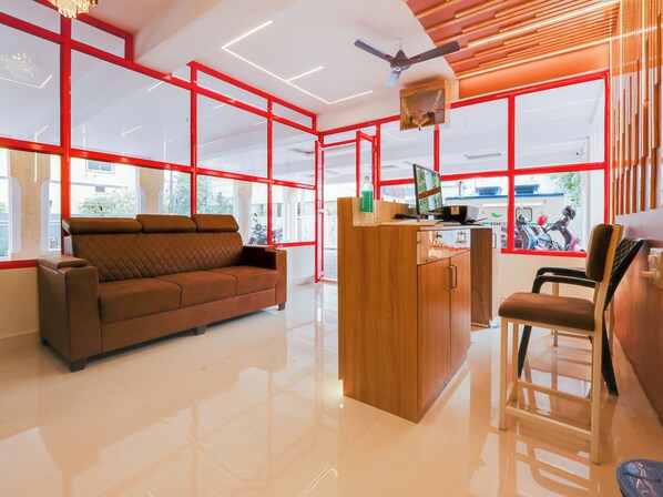 A modern interior with a sofa, wooden desk, and a chair. - Collection O White Ridge Kamineni (Hyderabad)