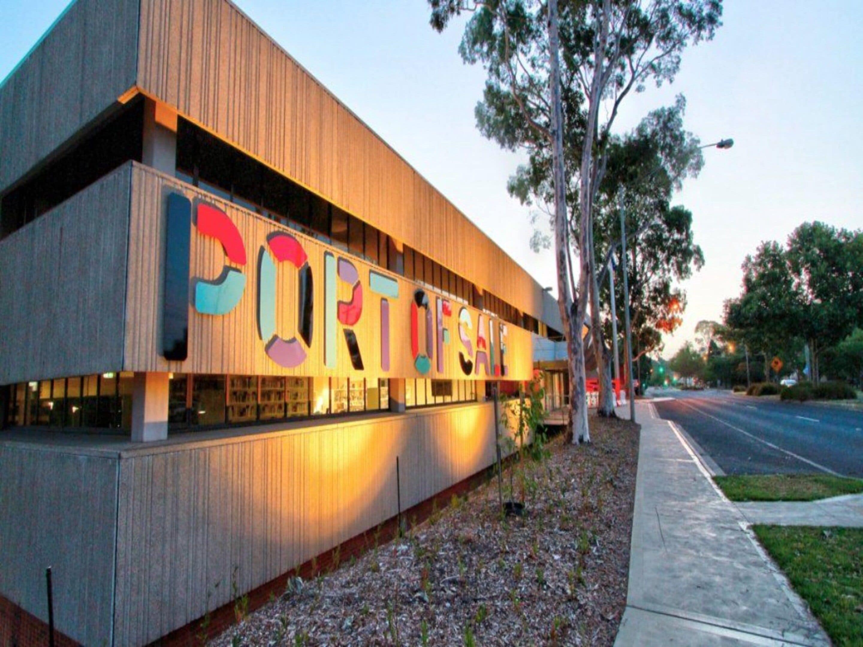 A building with a large sign reading 'PORTFOLIO' and a sidewalk in front.