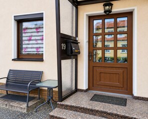 A building entrance with a mailbox, a bench, and a door with a window. - Holiday Home Lieselotte in the Heart of the Thuringian Forest (Brotterode-Trusetal)