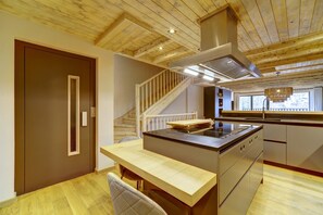 A modern kitchen with a wooden ceiling, a built-in stove, and a window with a view. - Casa Val de Ruda Luxe 78 by FeelFree Rentals (Naut Aran)