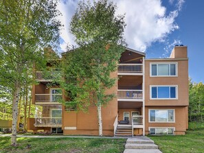 A multi-story residential building with balconies, a covered porch, and a clear sky. - Summit Nook | 2 bdrm Brian Head Condo (Brian Head)