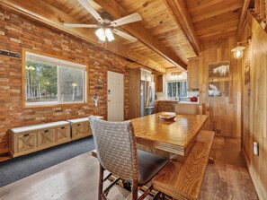 Un interior de madera con comedor, cocina y ventilador de techo.