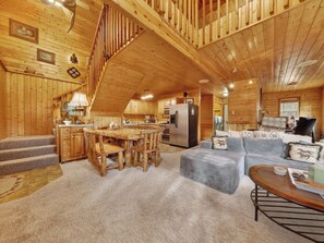 L’intérieur d’une cabane en bois comprend un coin repas, une cuisine et un salon.