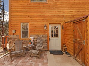 Une cabane en rondins avec des fondations en pierre, une porte en bois et une porte de garage.