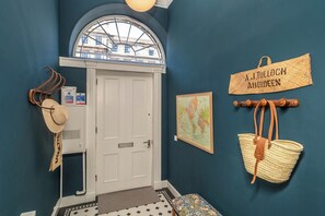 A hallway with a white door, a map, a hat, and a sign reading 'A.J. TULLOCH ABERDEEN'. - Elegant 3BR Georgian Gem in Central Edinburgh - Pass the Keys (Edinburgh)