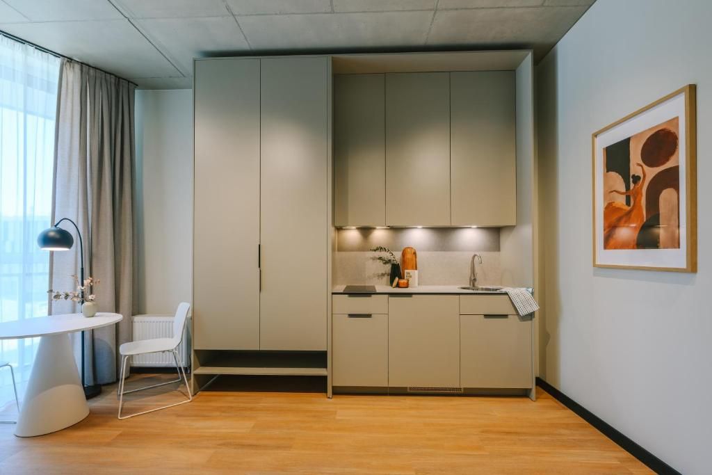 Moderni keittiö, jossa on ruokailutila, valkoinen tuoli ja pöytä.