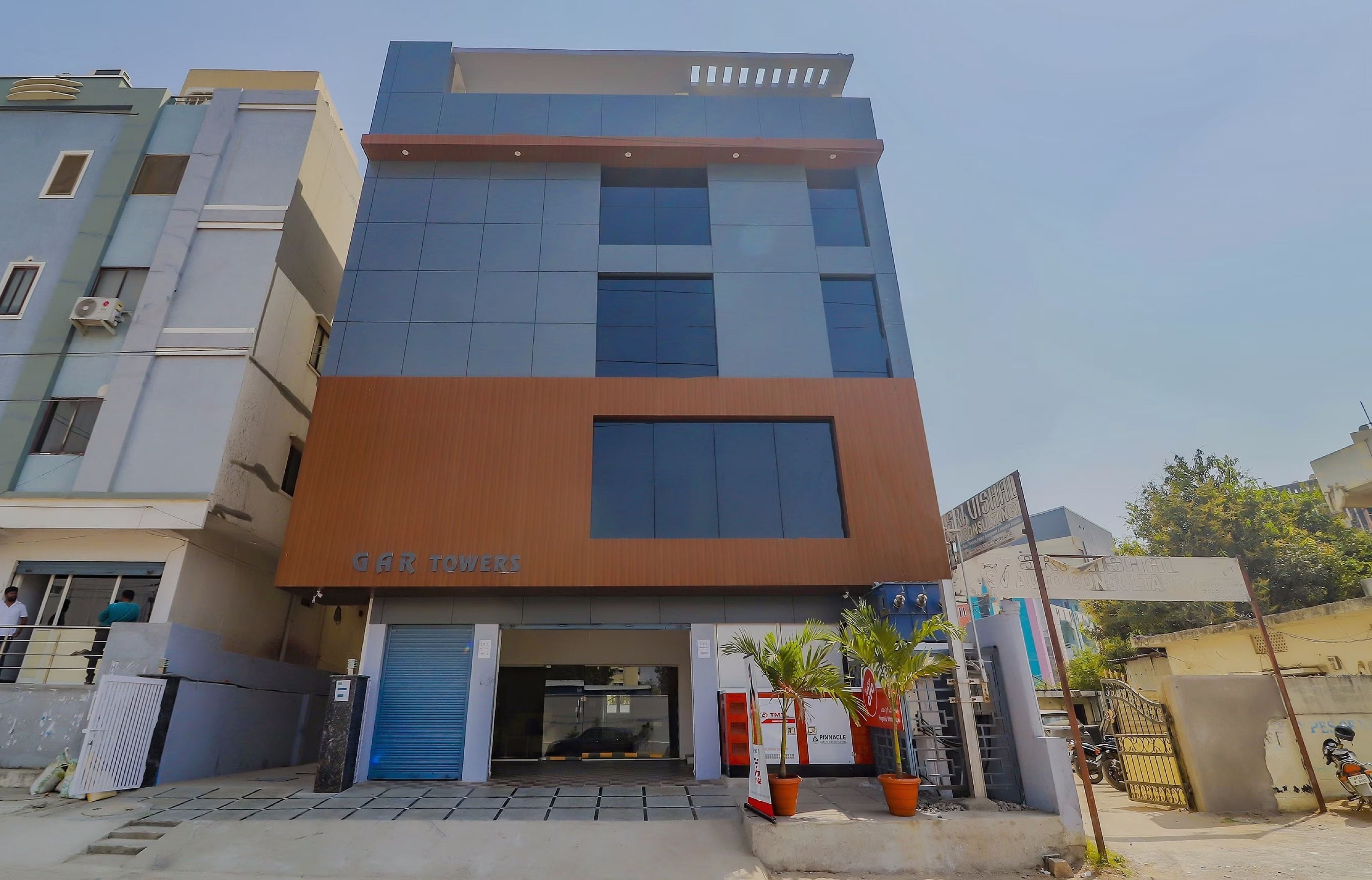 Un edificio de varios pisos con un letrero que dice 'GAR TOWERS' en la planta baja.