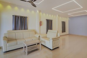Una sala de estar moderna con un sofá, un sillón y una pequeña mesa.